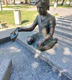 Kislány papírhajóval szobor