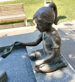 Kislány papírhajóval szobor