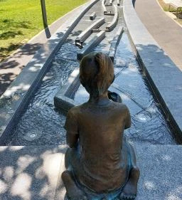 Kislány papírhajóval szobor