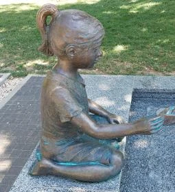 Kislány papírhajóval szobor