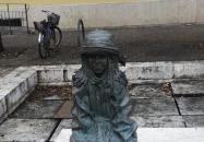 Kövön ülő kislány babával Szolnok