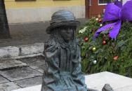 Kövön ülő kislány babával Szolnok